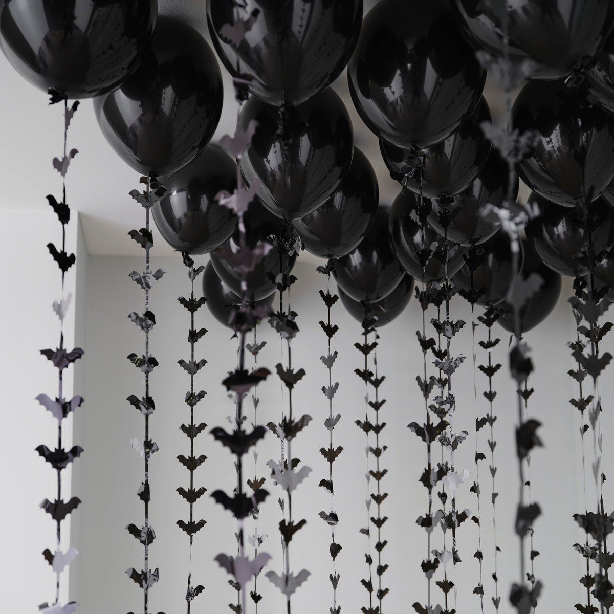 Halloween balloon ceiling kit with black balloons and bat tails