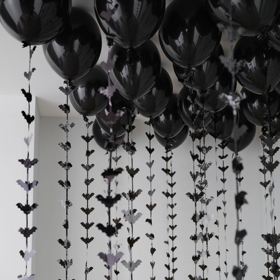 Halloween balloon ceiling kit with black balloons and bat tails